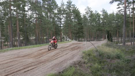 A-slow-motion-shot-of-a-beginner-motocross-rider-accelerating-over-a-table-top-on-a-motocross-track