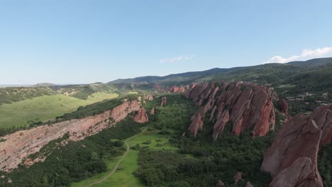 Breathtaking-scenery-of-sharp-rock-formation-in-a-green-valley,-aerial-landscape