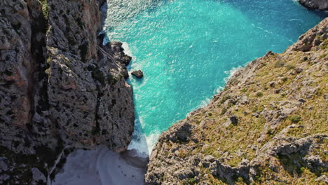 Aerial-View-Of-The-Narrow-Pebble-Beach-Of-Cala-de-Sa-Calobra-At-Torrent-de-Pareis-In-Sierra-de-Tramuntana,-Mallorca-Spain