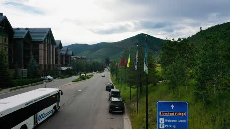 Aerial-ascending-shot-of-flags-and-traffic-in-the-Vail-village,-in-Colorado,-USA