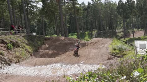 Eine-Zeitlupenaufnahme-Eines-Motocross-Fahrers,-Der-Während-Eines-Rennens-Mit-Hoher-Geschwindigkeit,-Geschick-Und-Kontrolle-über-Eine-Rampe-Fliegt