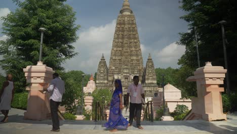 Monjes-Budistas-En-El-Complejo-Mahabodhi-Mahavihara,-Fachada-Del-Edificio-Del-Templo,-Devotos-Y-Turistas-En-El-Templo-Mahabodhi-A-La-Luz-Del-Día,-Plano-General