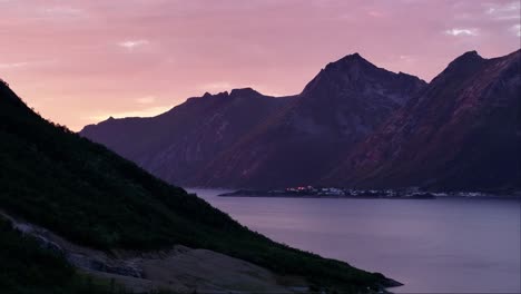 Majestuosas-Montañas-Sobre-El-Pueblo-De-Husoy-Contra-El-Cálido-Cielo-Del-Atardecer-En-Senja,-Troms-Y-El-Condado-De-Finnmark,-Noruega