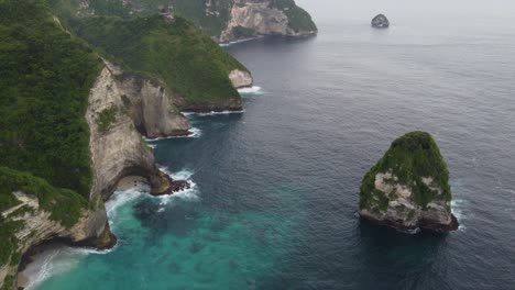 Steep-limestone-cliffs-at-craggy-coast-meet-the-Indian-Ocean,-Paluang-Cliff-on-Nusa-Penida-Island,-Indonesia