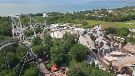 Toma-Aérea-Giratoria-De-Montañas-Rusas-En-El-Parque-De-Atracciones-Gardaland-Cerca-Del-Lago-De-Garda,-Italia