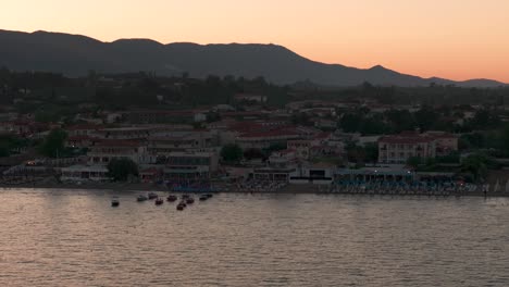 Drone-Shot-of-Sunset-Above-Laganas-Town,-Zakynthos-Island,-greece