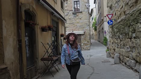 Edificios-Históricos-Con-Una-Mujer-Caminando-Por-Los-Callejones-De-Arezzo,-Toscana-Oriental,-Italia