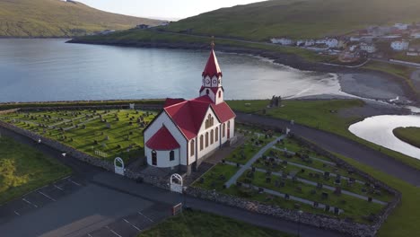 Aerial-orbit-view-of-church-in-Sandavagur,-Faroe-Islands