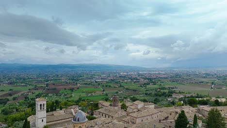 Flug-über-Die-Mittelalterliche-Hügelstadt-Assisi-Mit-Touristenattraktionen-Tagsüber-In-Umbrien,-Italien