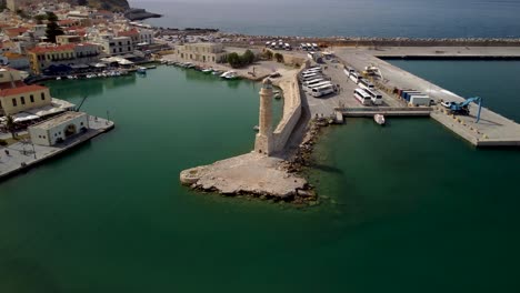 Drone-panning-shot-of-the-fire-tower-at-the-harbor-entrance-of-Rethymnon-in-Crete