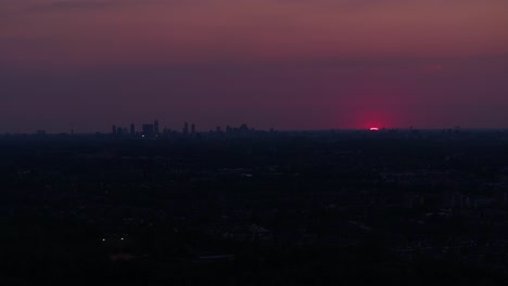 Die-Stadt-Liegt-Fast-In-Dunkelheit,-Da-Das-Einzige-Licht-Vom-Verblassenden-Roten-Sonnenuntergang-Kommt