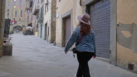 A-Female-Tourist-Exploring-Sights-In-The-Old-Town-Of-Arezzo,-Tuscany,-Italy