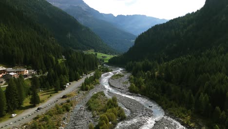 Scenic-River-Flowing-Through-Mountains-In-Alpe-Ventina,-Valmalenco,-Italy---aerial-shot