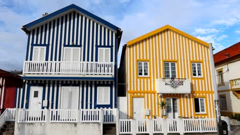Tilt-down-shot-of-two-stripped-and-colorful-houses-in-Costa-Nova,-Portugal