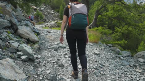 Girl-Backpacker-Walking-In-Mountain-Trail-In-Alpe-Ventina,-Italy---wide