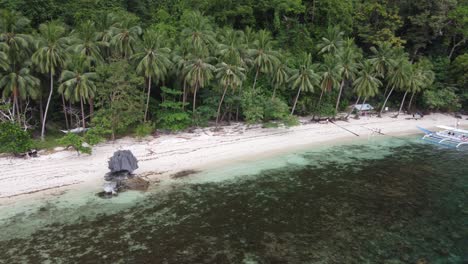 Aerial-view-of-the-scenic-white-sand-beach-of-Pasandigan-Cove-surrounded-by-rainforest-and-marine-reserve-on-Cadlao-Island,-Philippines