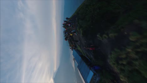 Drones-Volando-Alrededor-De-La-Multitud,-Monte-Batur-En-Bali,-Tiro-Vertical,-Hermoso-Amanecer,-Grupo-De-Excursionistas,-Llamaradas-Solares-En-Siluetas-De-Personas,-Vista-épica-Del-Pico-Del-Volcán,-Indonesia,-Caminata-Al-Amanecer-En-El-Monte-Batur