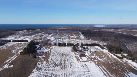 Endless-farmland-covered-in-snow-in-Michigan,-aerial-drone-ascend-view