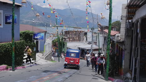 Tuk-tuk-and-tourists-travel-steep-cobble-street-in-San-Juan-la-Laguna