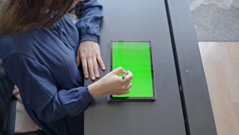 Female-office-worker-drawing-across-green-screen-notepad