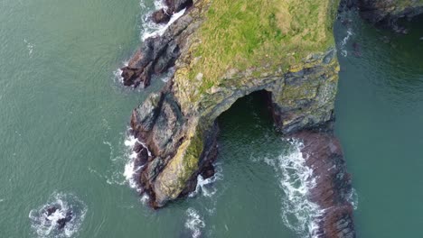 Aerial-view-of-a-sea-cave-on-a-headland-on-The-Copper-Coast-Waterford-Ireland-on-a-winter-day