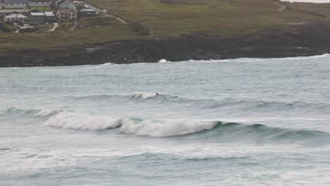 Hand-held-shot-of-a-surfer-attempting-to-surf-a-wave-at-Fistral-Beach