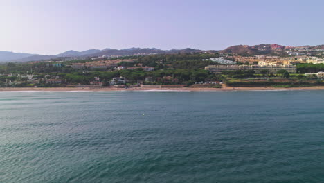Aerial-right-trucking-shot-of-Cabopino,-Spain,-on-a-clear-day