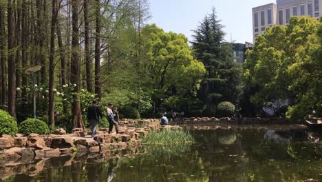 Peoples-Park-in-Shanghai-China-with-a-still-pond-and-people-relaxing-on-the-shore