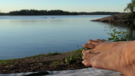 Calm-sea-bare-feet-close-up-at-summer-evening-sunset