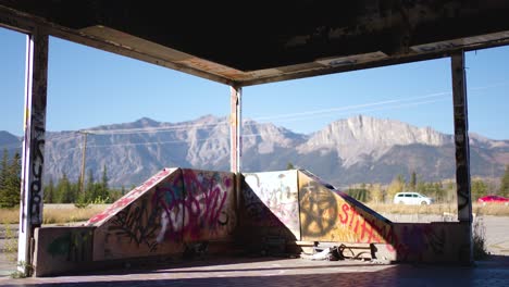 Kanadische-Rocky-Mountains,-Gesehen-Durch-Die-Zerbrochenen-Fensterscheiben-Des-Verlassenen-Graffiti-Fort-Chiniki-Gebäudes-Am-Trans-Canada-Highway-One-In-Der-Nähe-Von-Canmore,-Alberta