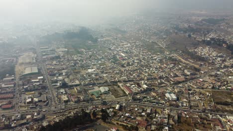 Aerial-view-of-Quetzaltenango-city-in-fog,-Guatemala-Central-America