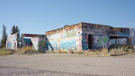 Schwenkaufnahme-Des-Fort-Chiniki,-Verlassene-Graffiti-Straßenkunst,-Bemalte-Tankstelle-Am-Highway-One-In-Der-Nähe-Von-Canmore,-Alberta,-Kanada