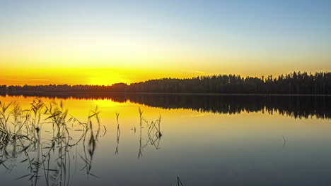 Ein-Zeitraffervideo-Fängt-Die-Faszinierende-Landschaft-Eines-Ruhigen-Sees-Ein,-In-Dem-Sich-Der-Sonnenuntergang-Spiegelt