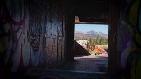 Die-Kanadischen-Rocky-Mountains-Durch-Den-Mit-Graffiti-Bemalten-Flur-Des-Verlassenen-Fort-Chiniki-Gebäudes-Außerhalb-Von-Canmore,-Alberta,-Kanada