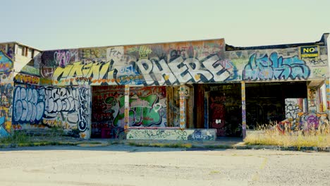 Panorámica-A-Través-Del-Fuerte-Chiniki-Graffiti-Abandonado-Arte-Callejero-Pintado-Gasolinera-Y-Destino-Turístico-Junto-A-La-Autopista-Uno-Cerca-De-Canmore-Alberta-Canadá