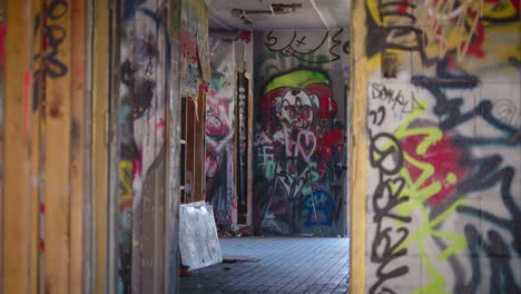 Der-Kameraständer-Konzentriert-Sich-Auf-Eine-Gruselig-Aussehende-Graffiti-Zeichnung-Durch-Den-Eingang-Eines-Verlassenen-Gebäudes-In-Canmore,-Alberta,-Kanada