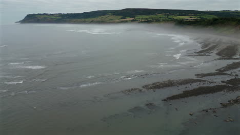 Establishing-Drone-Shot-of-Misty-North-Yorkshire-Coast-Near-Robin-Hood's-Bay