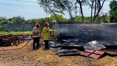 Firefighters-spraying-water-on-aftermath-of-industrial-fire