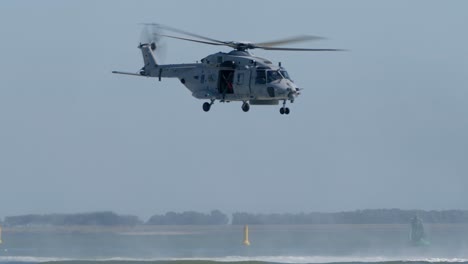 Helicóptero-NH-90-Volando-A-Baja-Altura-Sobre-El-Mar,-Cabrestante-Parado-En-La-Puerta