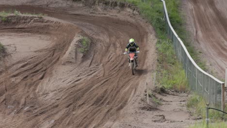 Eine-Zeitlupenaufnahme-Eines-Enduro-Fahrers,-Der-Auf-Einer-Motocross-Strecke-Fährt-Und-Sich-Einer-Anliegerstraße-Mit-Hoher-Geschwindigkeit-Nähert