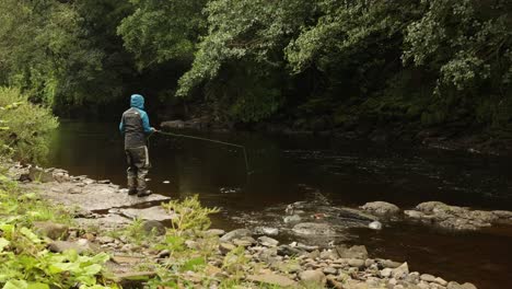 Hand-held-shot-of-a-flyfisherman-casting-multiple-times-into-a-small-stream