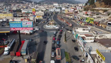 Low-aerial-follows-vehicle-traffic-on-Quetzaltenango,-Guatemala-street