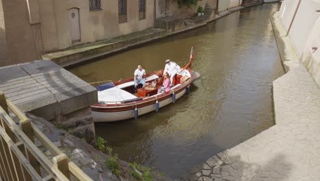 Un-Barco-Con-Tres-Pasajeros-Se-Desliza-Bajo-Un-Puente-En-Praga.