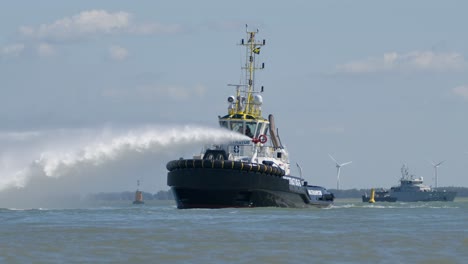 Multratug-6-Tugboat-Using-Water-Cannon,-Ship-Display-at-Sea,-Sunny-Day