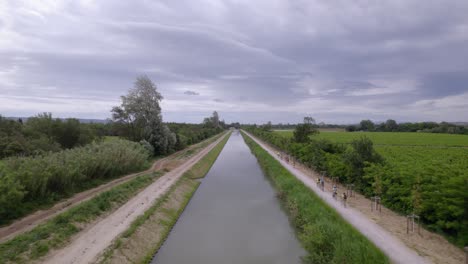Luftaufnahme-Entlang-Eines-Flusses-Mit-Behinderten-Rennfahrern,-Die-Am-Narbonne-Handicap-Rennen-Teilnehmen