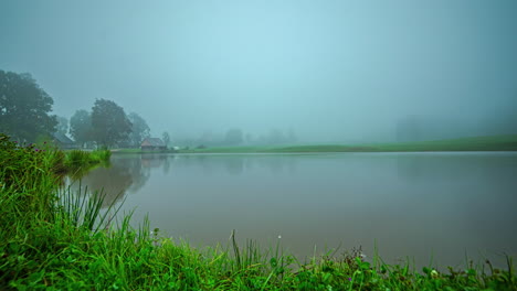 Misty,-foggy-morning-and-overcast-day-over-a-cottage-by-a-lake---time-lapse