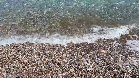 Cobble-Beach-in-Rhodos,-Greece-with-Marmaris-in-the-far-end,-blue-crystal-clear-water,-travel-destination-and-establishing-shot-filmed-in-4K