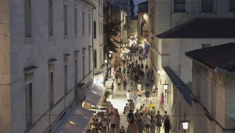 Nachtleben-Auf-Der-Straße-In-Der-Altstadt-Von-Zadar,-Wo-Touristen-In-Der-Kühle-Der-Nacht-über-Weiß-Getünchte-Steine-Spazieren-Und-Die-Geschichte-Genießen