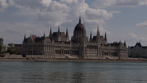 Edificio-Del-Parlamento-Húngaro,-Toma-Estática,-A-Través-Del-Danubio,-Día-Caluroso-Y-Soleado