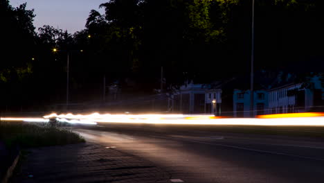 Zeitraffer-Von-Schnell-Fahrendem-Verkehr-Mit-Eingeschalteten-Scheinwerfern-Bei-Sonnenuntergang-–-Schwenk-Von-Links-Nach-Rechts